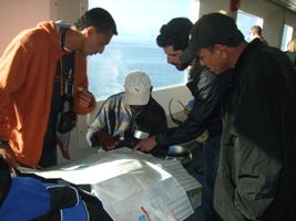 Fishermen exchange delegation viewing catch reports in Vancouver, BC.