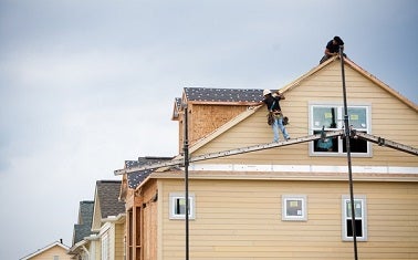 Workers install solar panels on a home in Austin's Mueller neighborhood, a project of Pecan Street Inc.