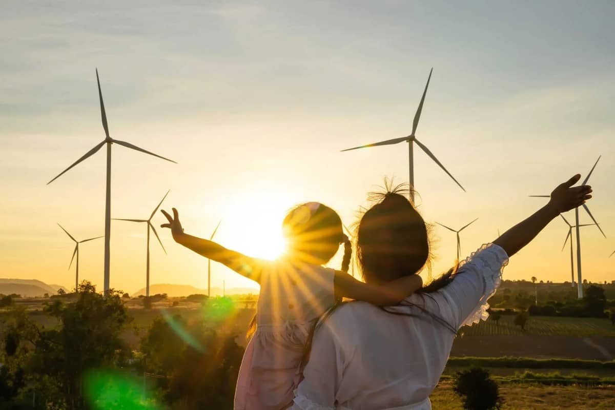 Family staring at wind turbines with a sunset