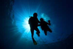 Two scuba divers in silhouette