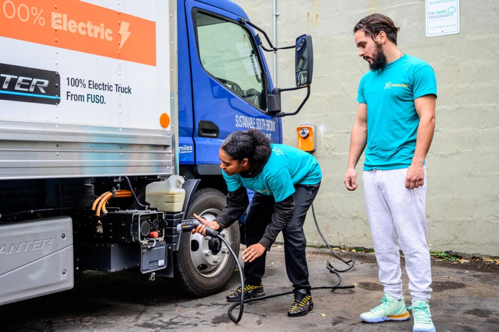 Hope Foundation staff, Auri Williams and Ivan Diaz, charging electric truck