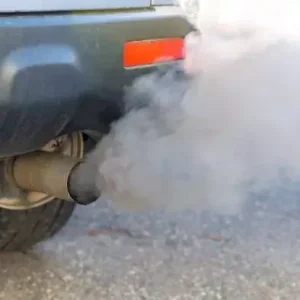 A car with grey exhaust pouring out of its tailpipe