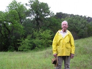 Dr. Gene Murph stands in front of prime golden-cheeked warbler habitat on his Texas ranch