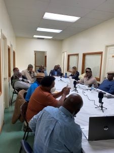 Black farmer members of the Federation of Southern Cooperatives sit around a conference room table discussing their experiences with credit access and climate change.