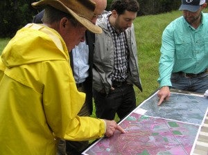 Dr. Murph points to the warbler habitat on an aerial map of his property