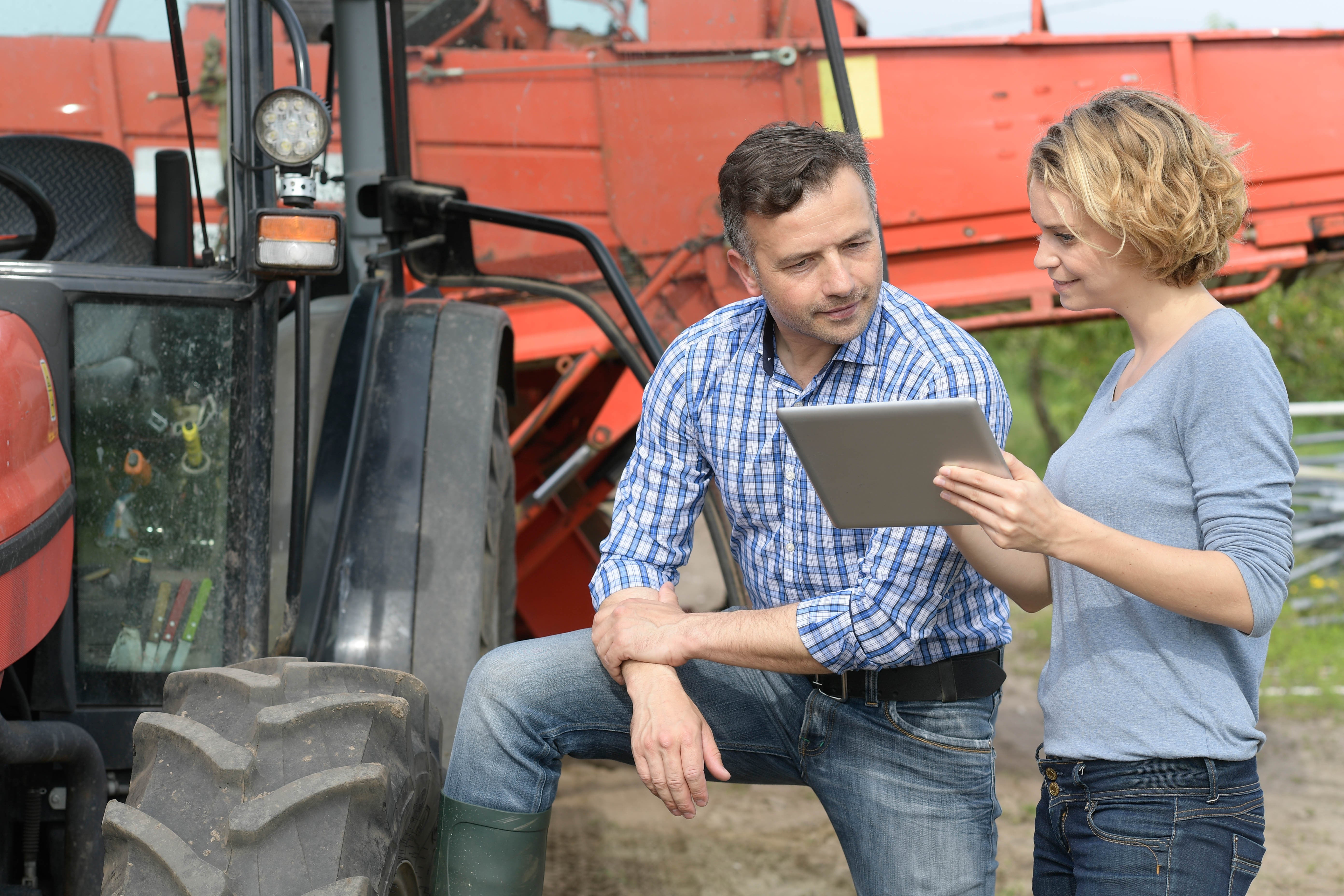 Man and woman review farm data on a tablet