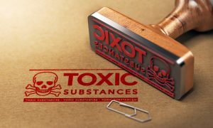 A rubber stamp lies on its side to the right of the photo. To the left, you see the stamped image of a skull and crossbones and the words Toxic Substances