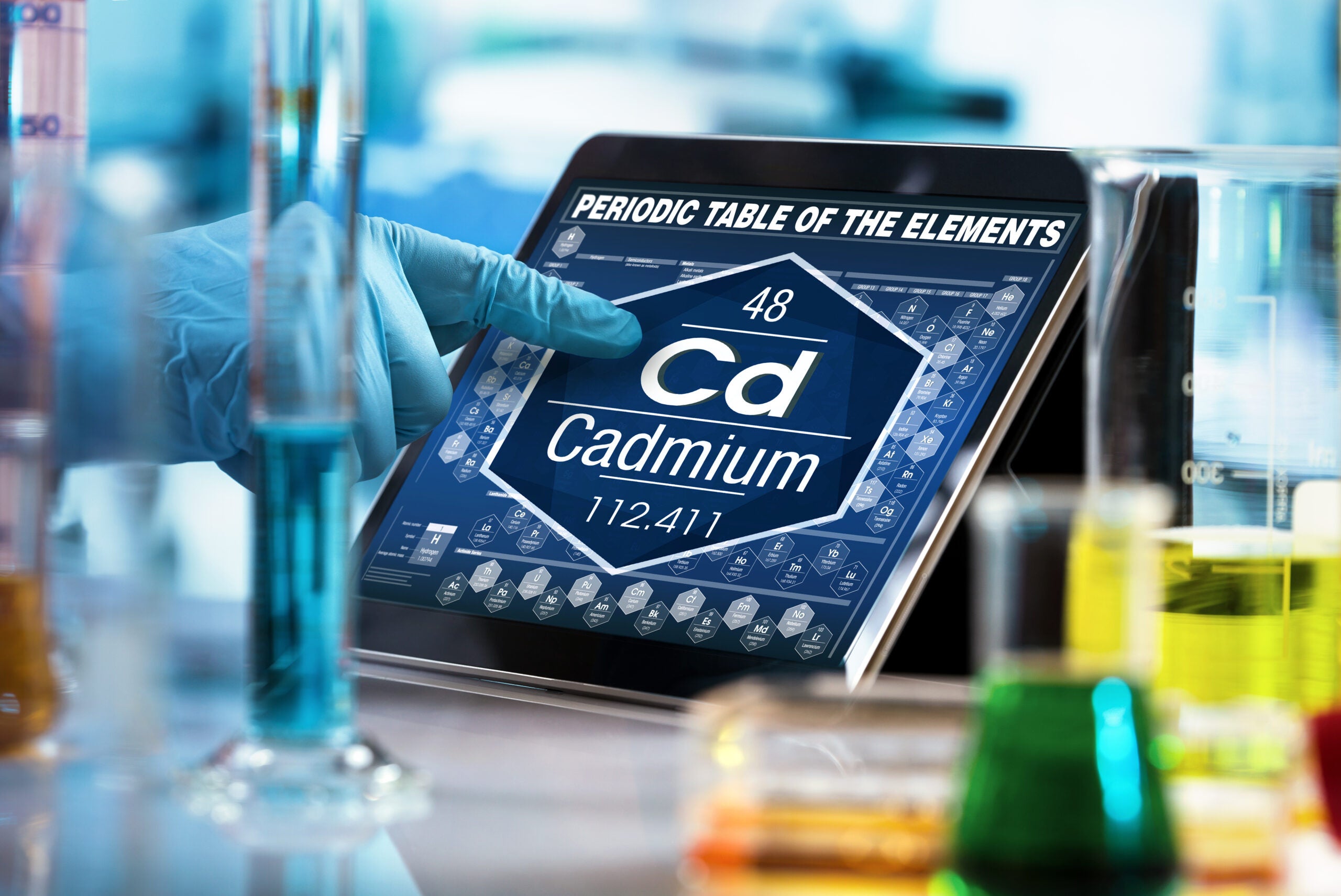 Scientist working on a digital tablet showing data on the chemical element Cadmium