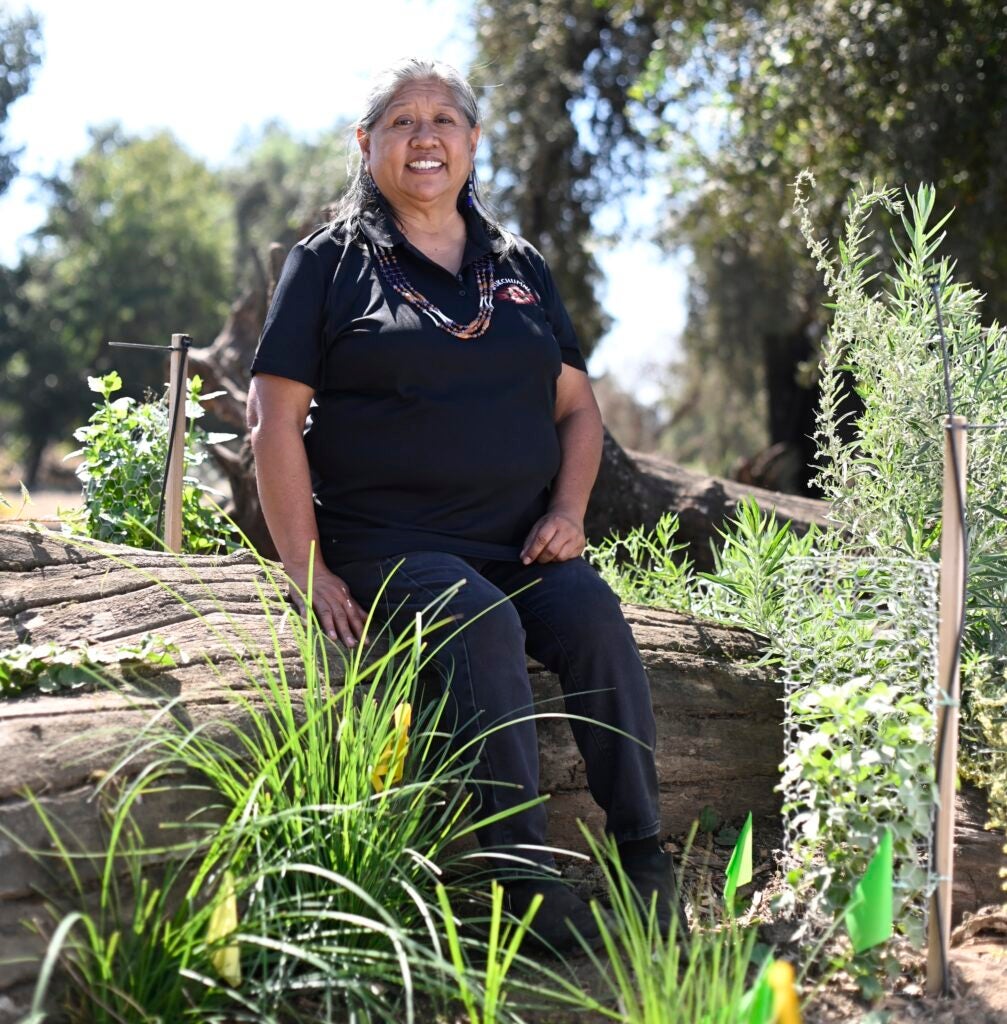 Darlene Franco sits on a log at a restoration site