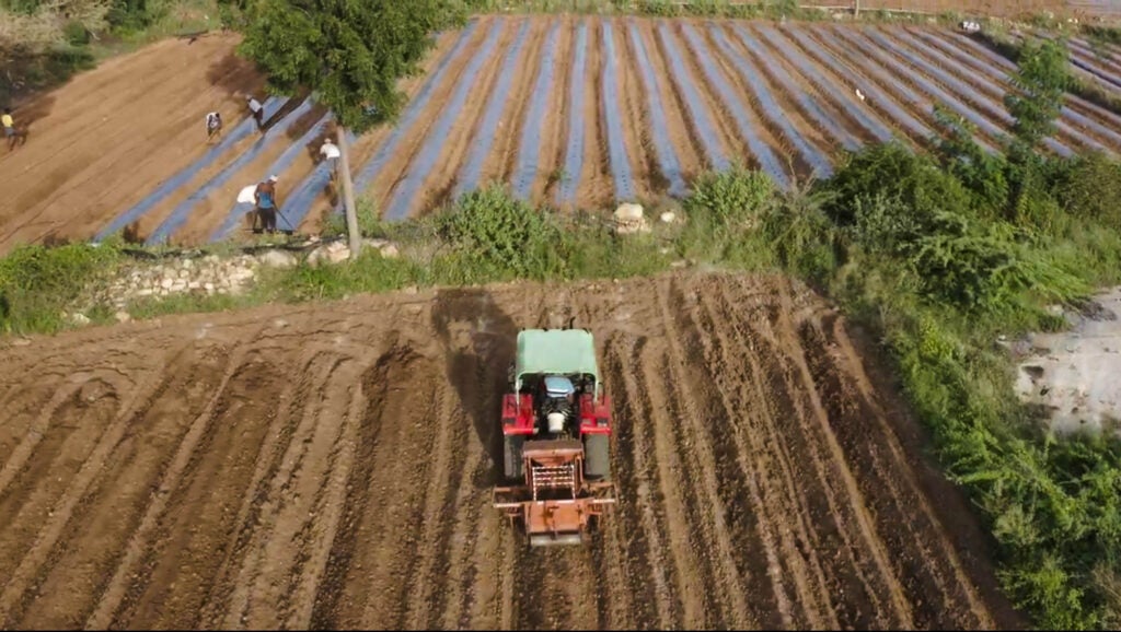 An aerial view of a tractor on a field in India.