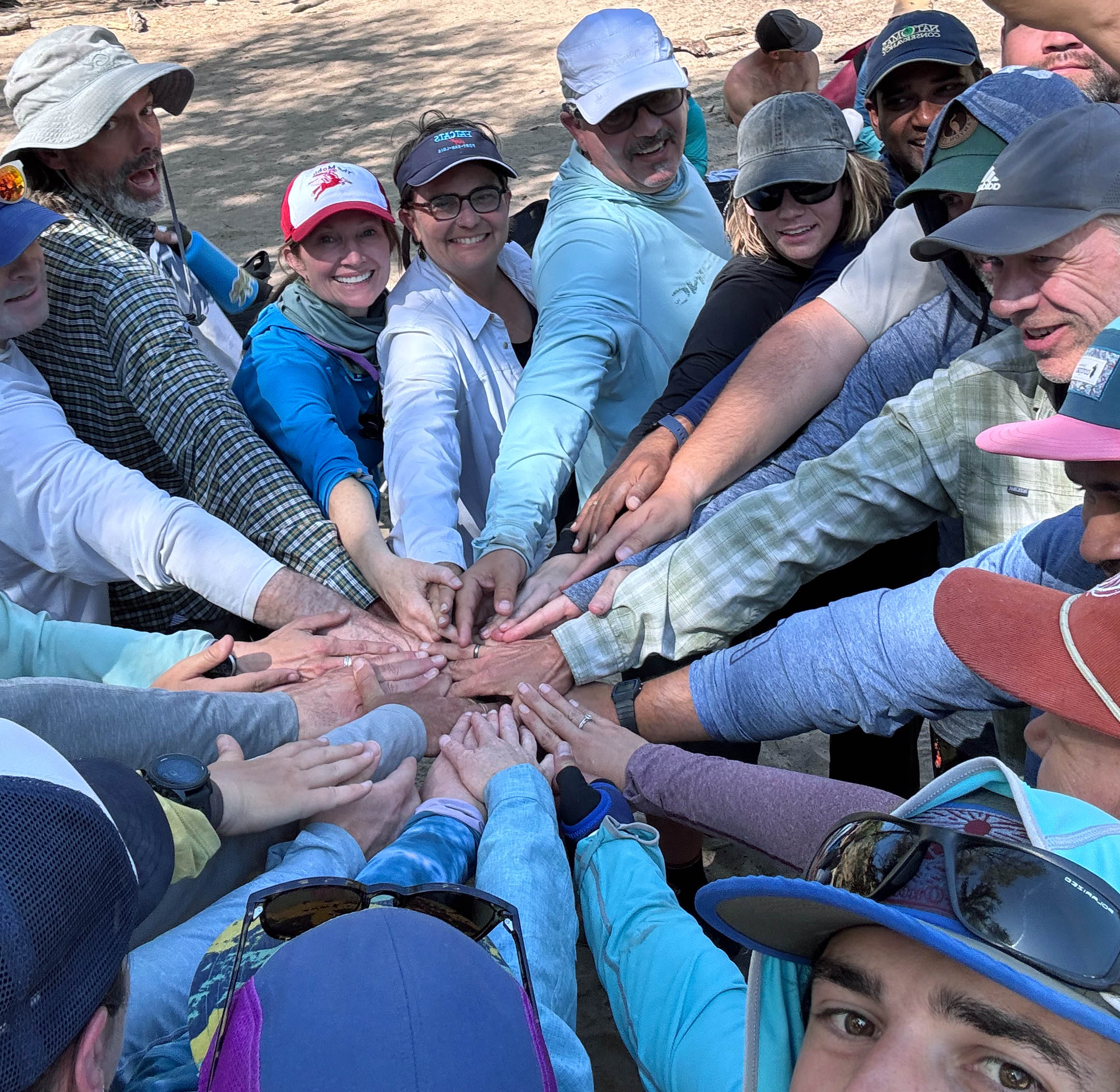 Group putting all their hands together to form a circle in the middle.