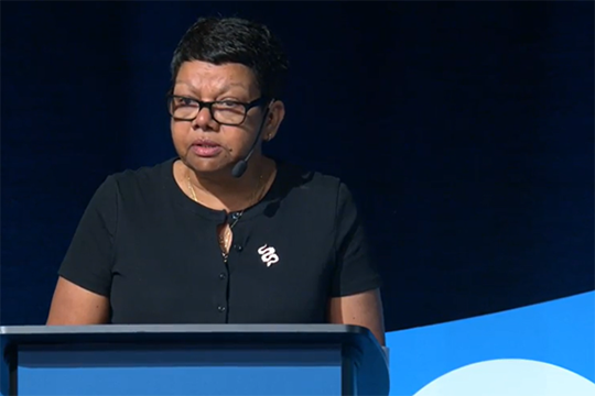 Kay Blades gives speech at podium